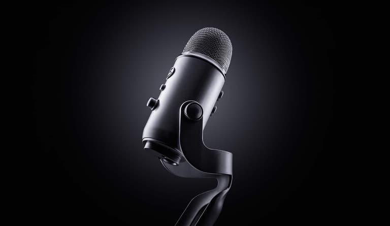 Blue Yeti microphone in black, angled on a dark background with soft lighting.