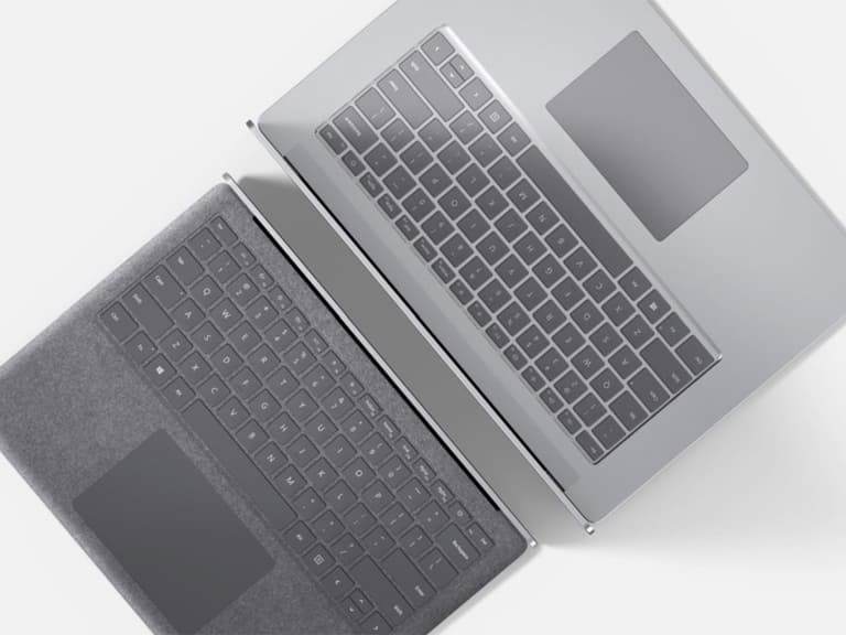 Microsoft Surface Laptop 3 in silver and grey, top-down view showing keyboards and touchpads.