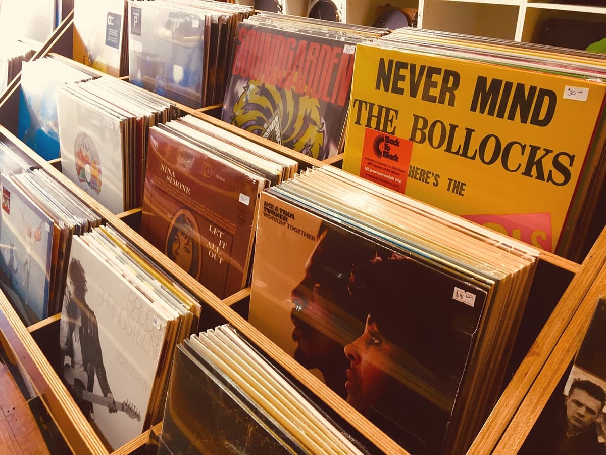 Vinyl records displayed in wooden crates at a Melbourne record store, featuring classic album covers.