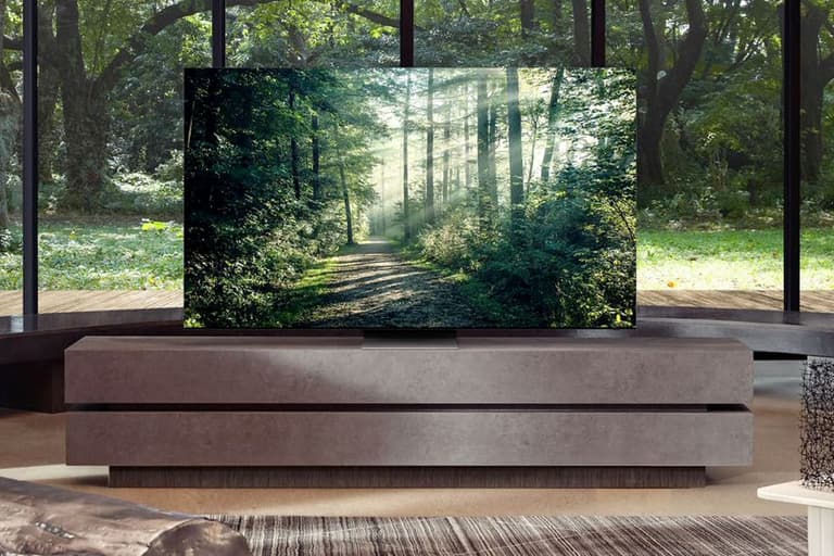 Samsung Neo Qled TV displaying a forest scene, paired with a sleek Dolby Atmos soundbar in a modern living room.