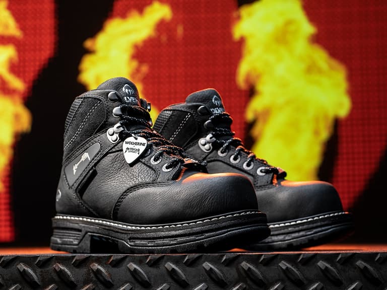 Wolverine x Metallica Encore boots in black leather with guitar pick detail, set against a fiery background.