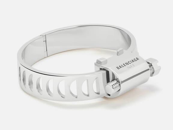 Balenciaga silver bracelet resembling a hose clamp with engraved logo and screw detail.