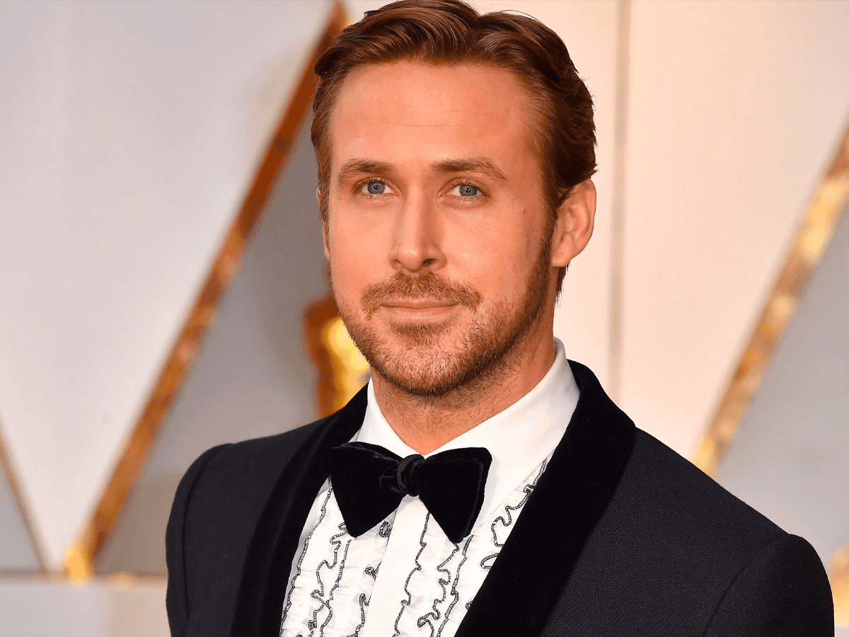 Ryan Gosling wearing a tuxedo with a ruffled shirt and bow tie at an awards event.