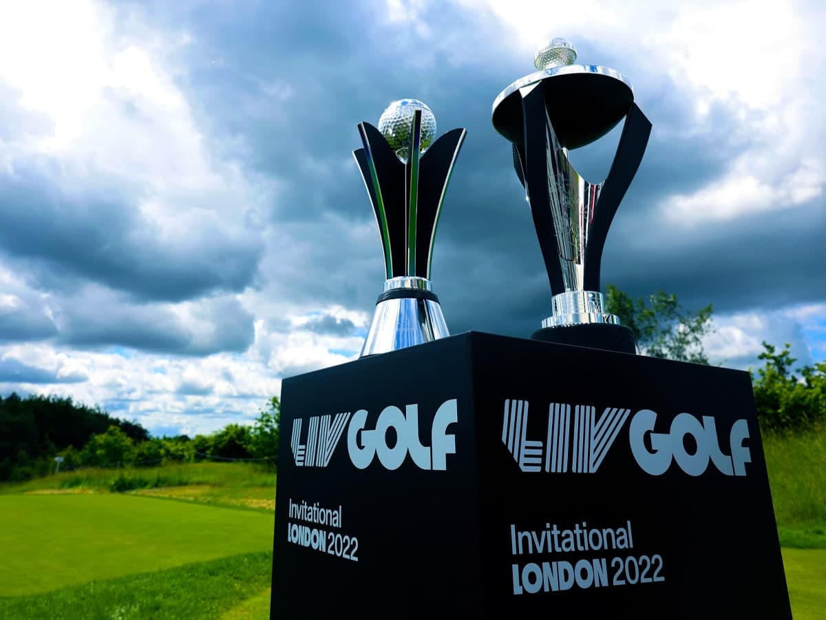 LIV Golf Invitational London 2022 trophies on display against a cloudy sky backdrop.