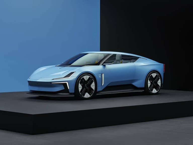 Polestar 6 in blue displayed on a platform, showcasing sleek design and futuristic headlights.