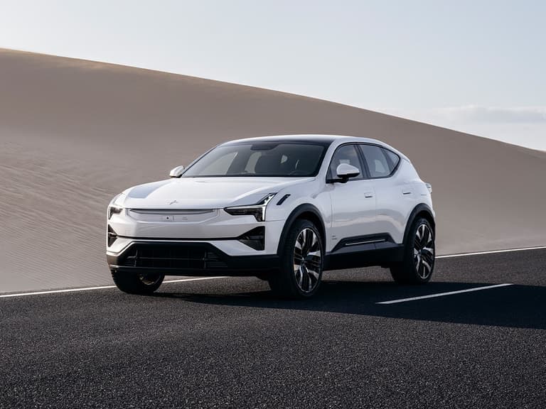 Polestar 3 in white parked on a desert road with sand dunes in the background.