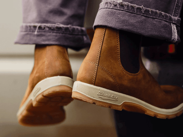 Blundstone 1320 Chelsea boots in tan leather with white soles, worn with frayed grey jeans.