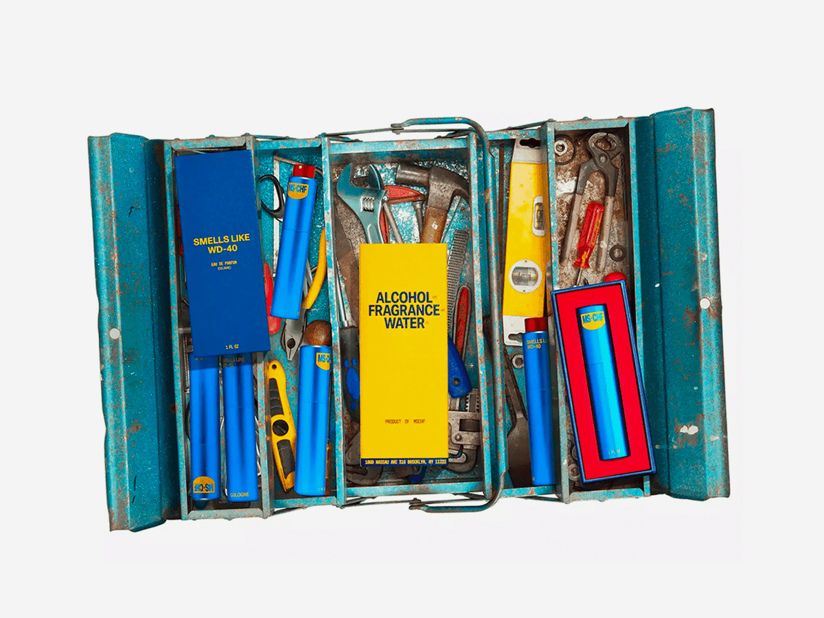 WD-40-inspired cologne set in a blue toolbox with tools, featuring bold yellow and blue packaging.