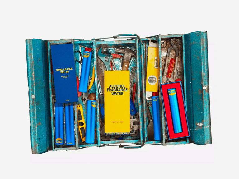 WD-40-inspired cologne set in a blue toolbox with tools, featuring bold yellow and blue packaging.