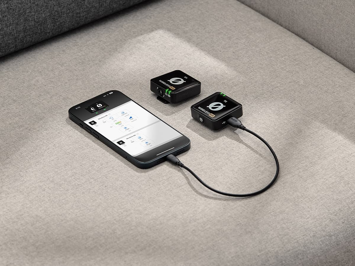 Røde Wireless GO II connected to smartphone on grey fabric surface.