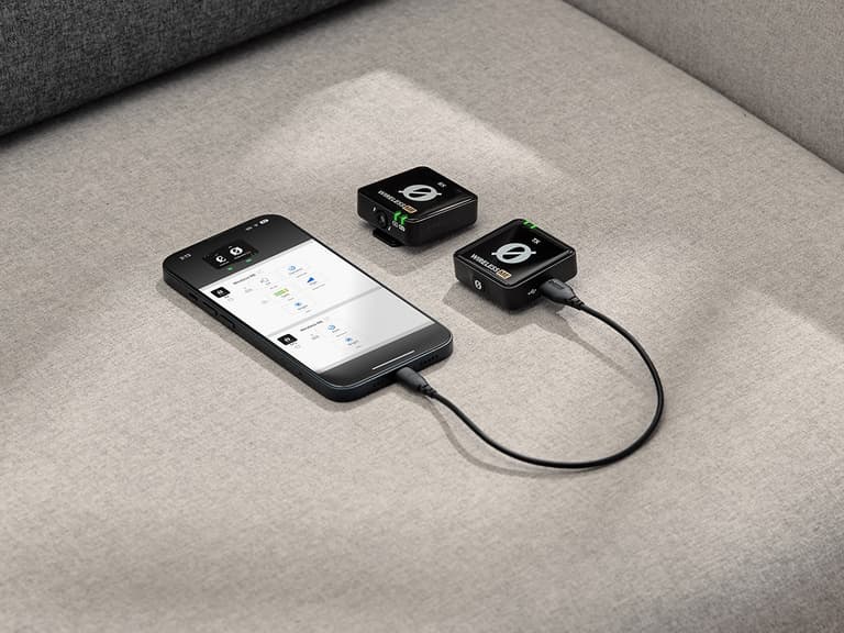 Røde Wireless GO II connected to smartphone on grey fabric surface.