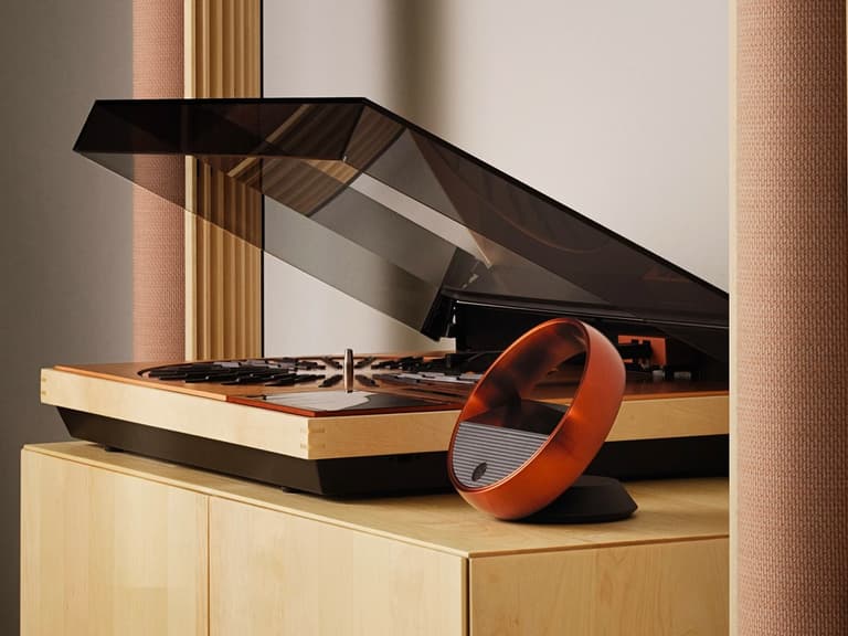 Bang & Olufsen Beosystem 72-23 with open lid on wooden cabinet, featuring sleek black and orange design.