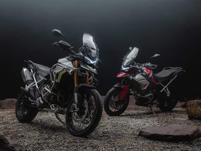 Triumph Tiger 900 Rally and GT Aragon Editions in a dimly lit rocky setting.