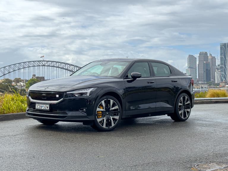 Polestar 2 in black parked with Sydney Harbour Bridge and skyline in the background under a cloudy sky.