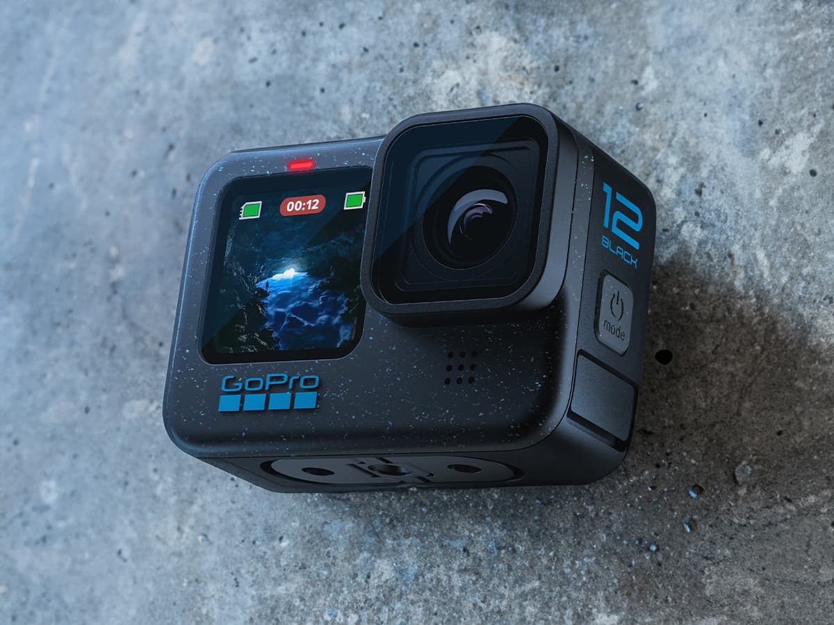 GoPro Hero 12 Black camera on concrete surface, displaying video recording on front screen.