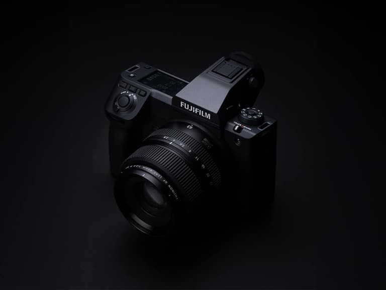 Fujifilm GFX 100 II camera in black, angled view with lens, set against a dark background.