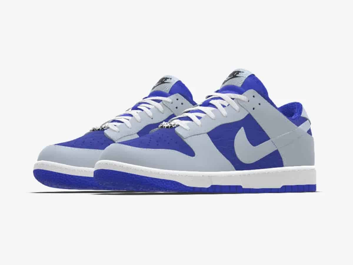 Nike Dunk Low sneakers in blue and grey with white laces, displayed on a white background.