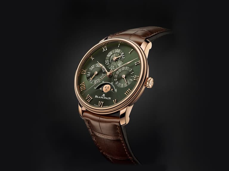 Blancpain Villeret Quantième Perpétuel watch with green dial and brown leather strap, set against a dark background.