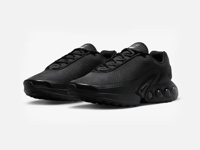 Nike Air Max Dn sneakers in black and dark smoke grey, featuring a textured upper and distinctive sole design.