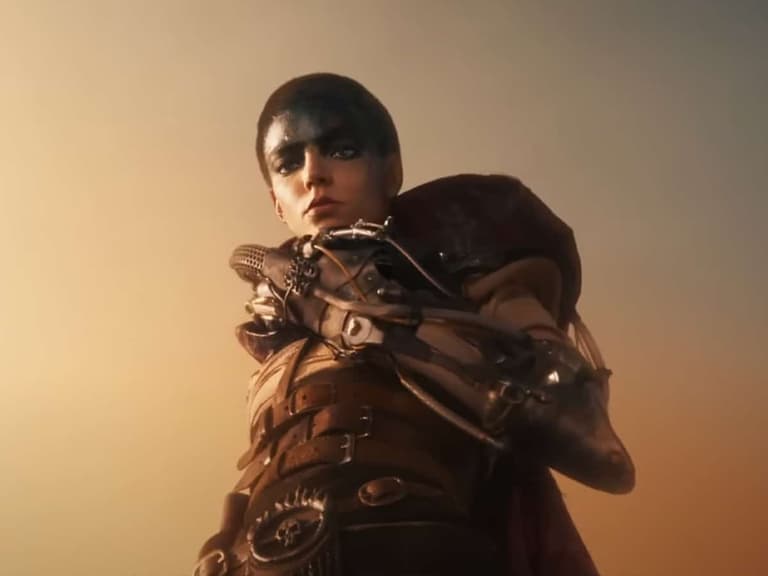 Anya Taylor-Joy as Furiosa wearing armour and face paint against a dusky sky in a scene from the 2024 film.