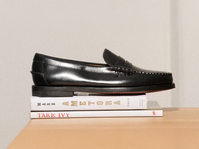 Sebago Classic Dan Loafers in black leather resting on stacked books on a wooden surface.