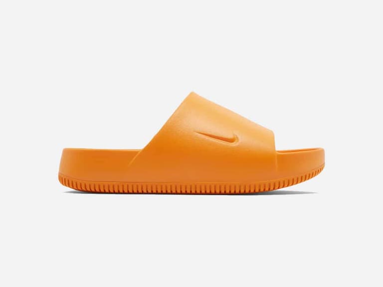 Nike Calm Slide in bright mandarin, side view, showcasing its minimalist design and textured sole.