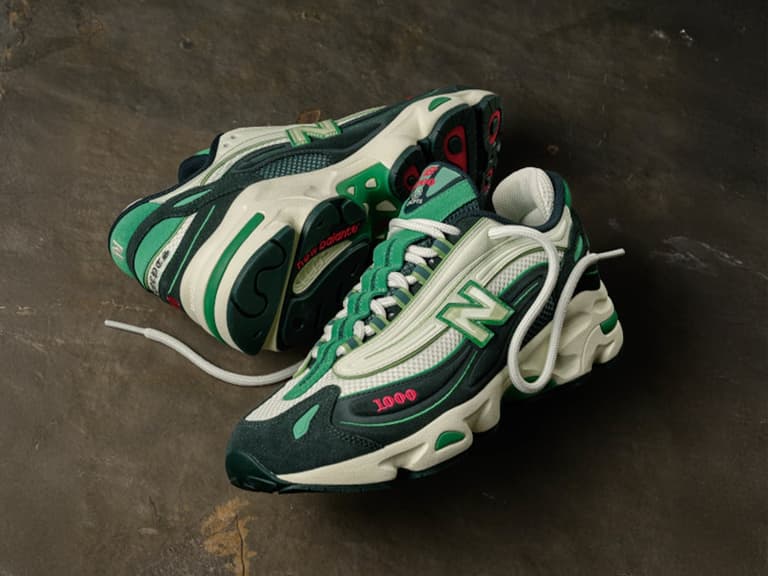 New Balance x CNCPTS 1000 sneakers in green and white with red accents on a dark textured surface.