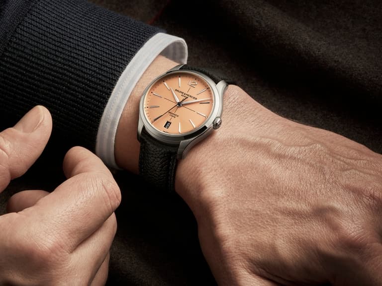 Clifton Baumatic M0A10778 watch with a salmon dial and black leather strap on a man's wrist.