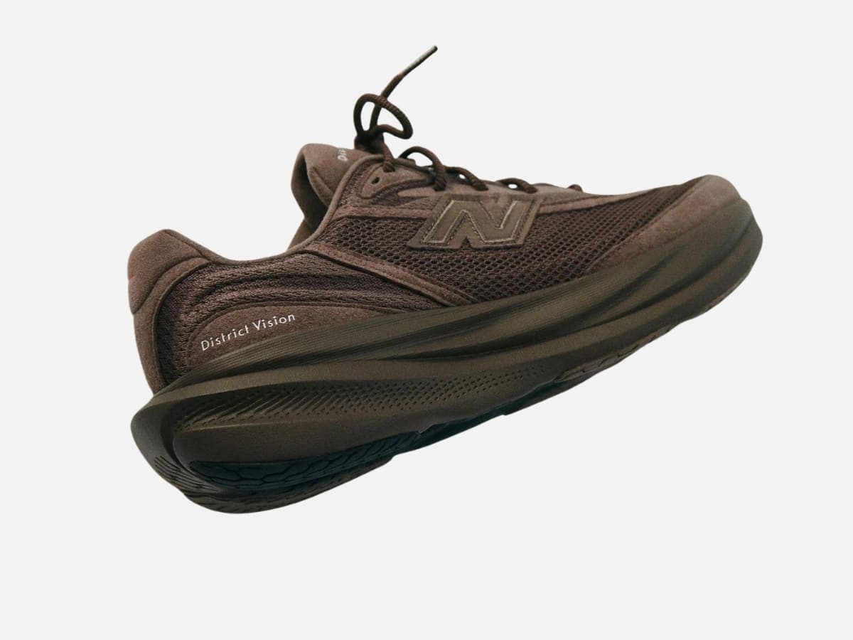 New Balance x District Vision 1080v15 in Cortado Brown, side view showcasing mesh texture and logo.