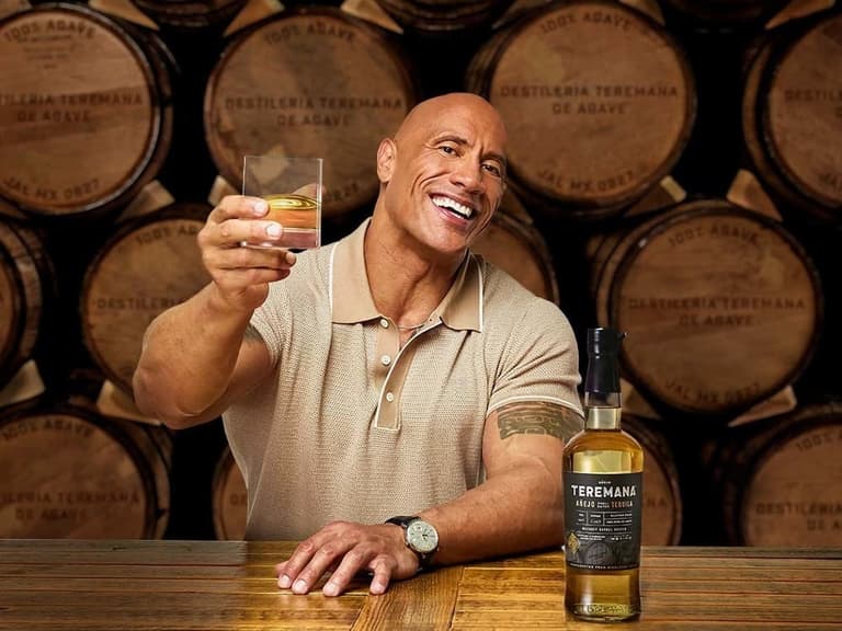 Dwayne Johnson raises a toast with a bottle of Teremana Anejo tequila at the Destileria Teremana de Agave barrel room