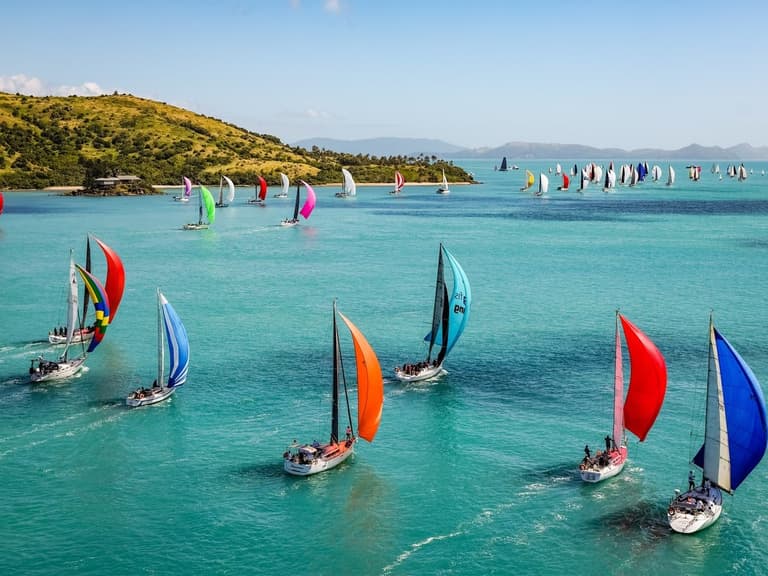 Spinnakers of the Hamilton Island Race Week fleet racing through the Whitsundays