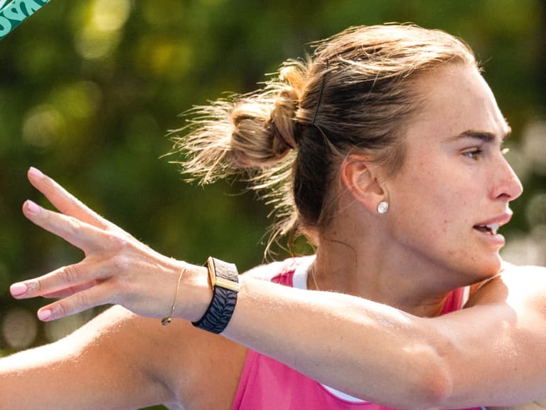 Aryna Sabalenka follows through on a forehand wearing a tiger-stripe WHOOP band with a gold clasp on her wrist.